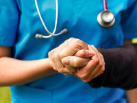 Health care provider holding a patient’s hand