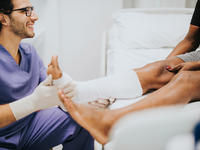 Doctor wrapping foot and calf of patient