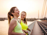Two athletic women, smiling and laughing outside
